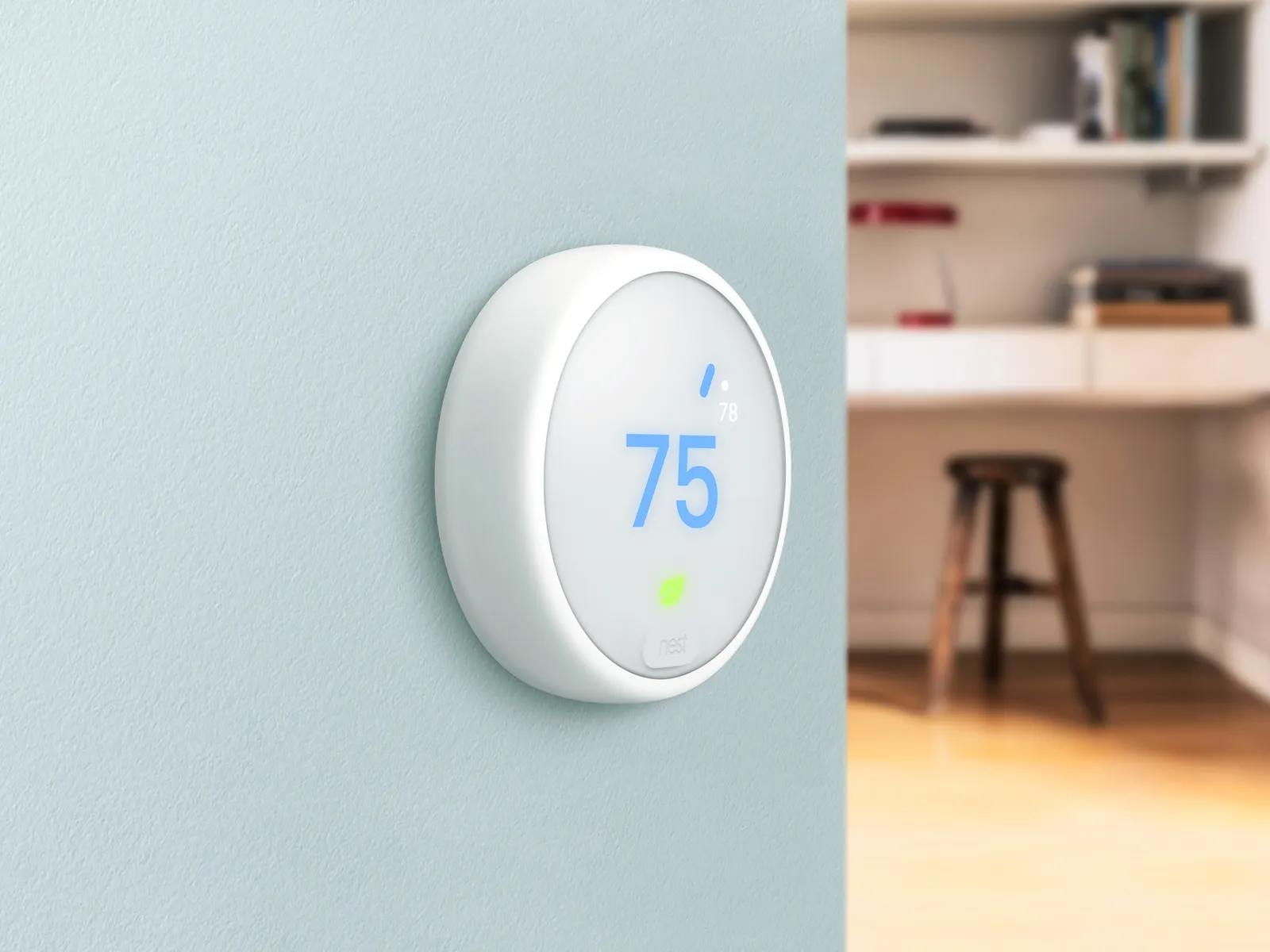 Smart thermostat set to 75 degrees on a home wall